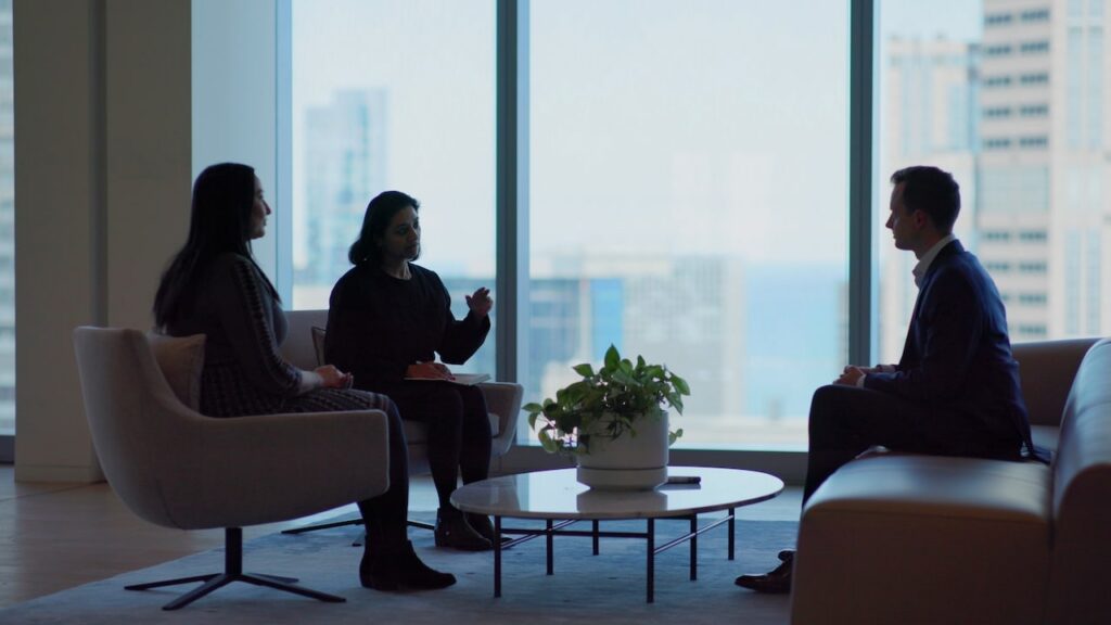 Three people having a meeting in an open space.