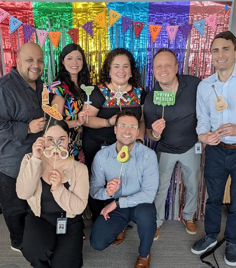 A group of Antares employees posing with photo booth props.