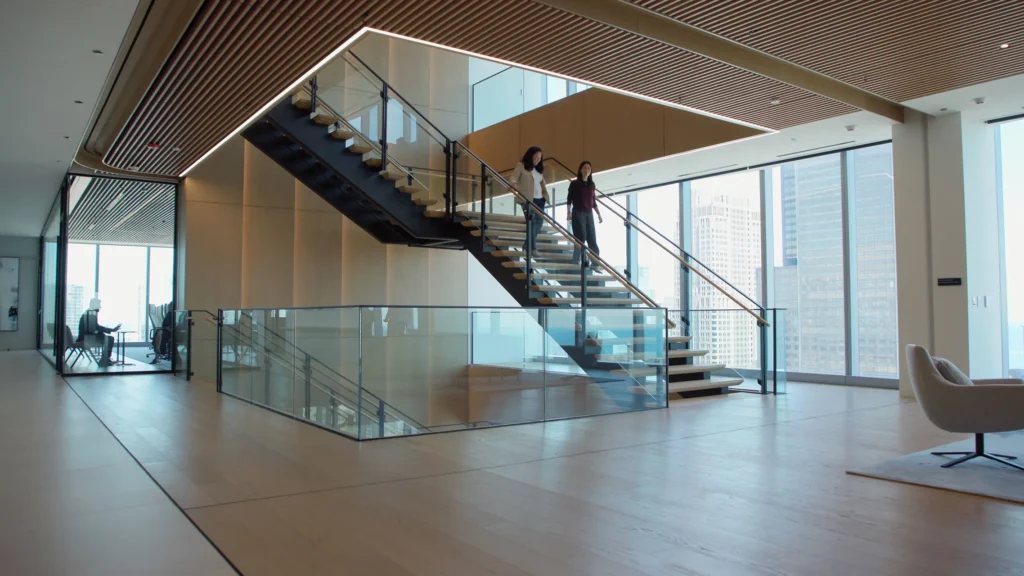 Two Antares employees descending a staircase in an office building.