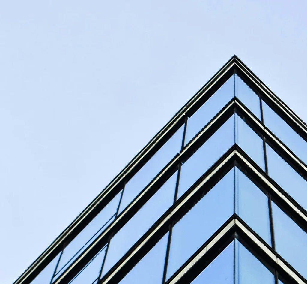 A glass skyscraper against a clear, blue sky.