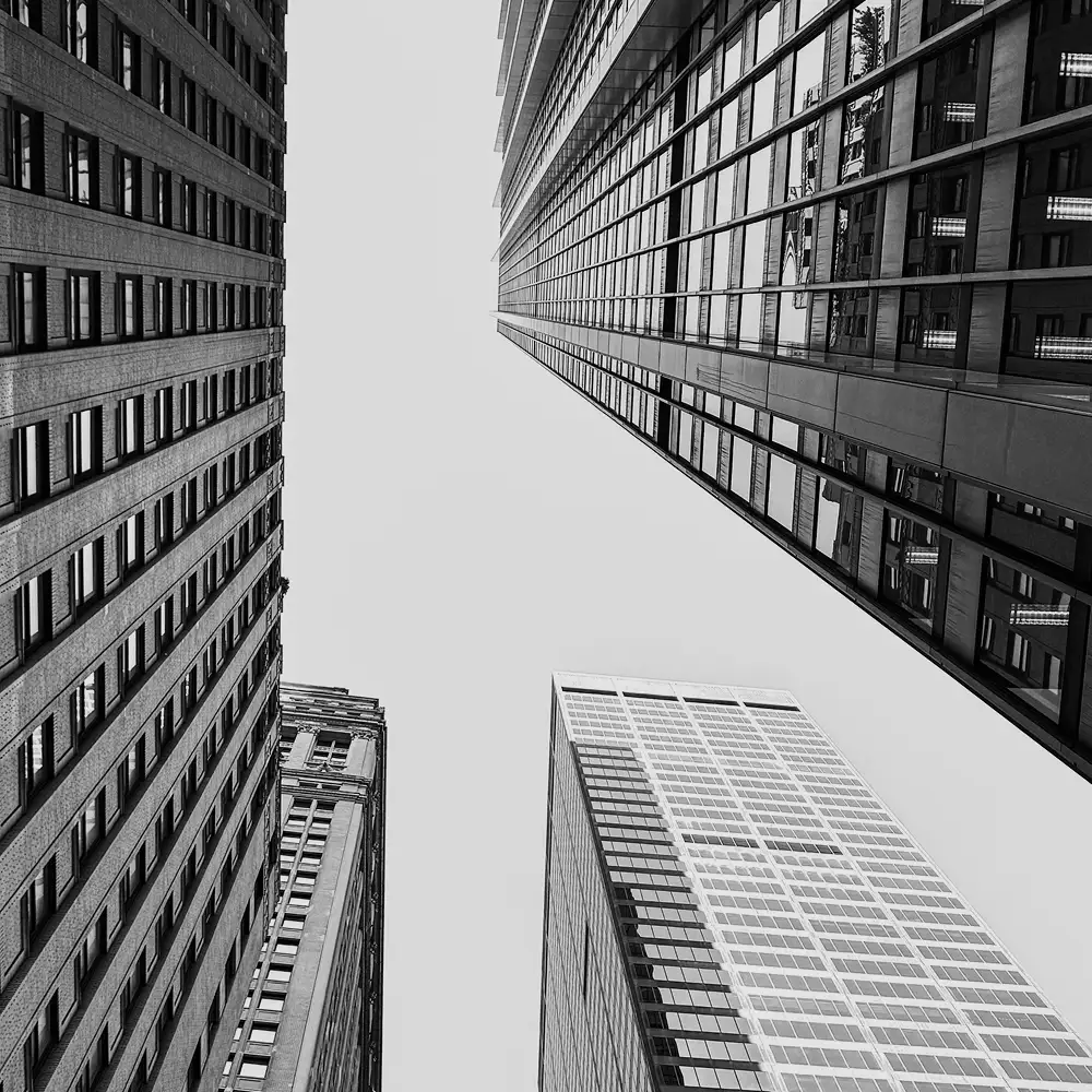 A black and white photo of buildings from below.