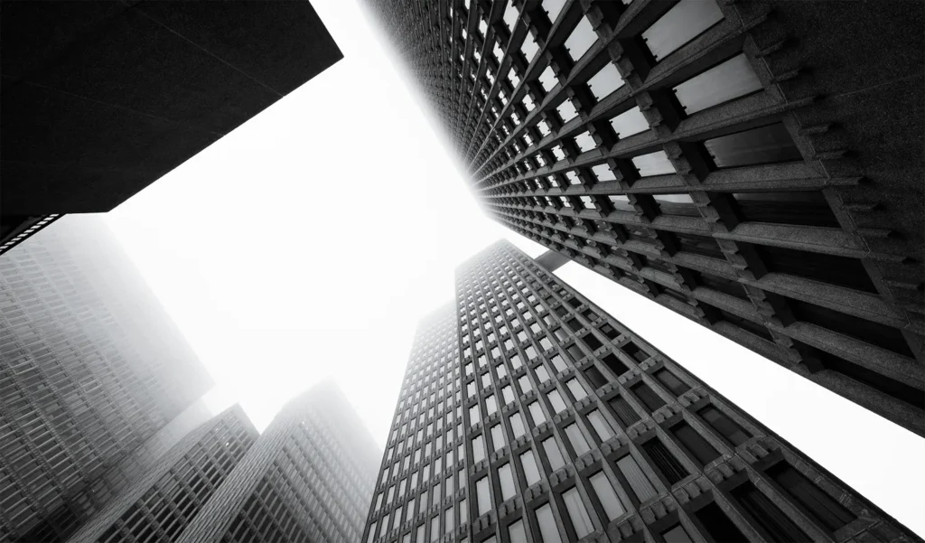 A black and white photo of buildings from below.