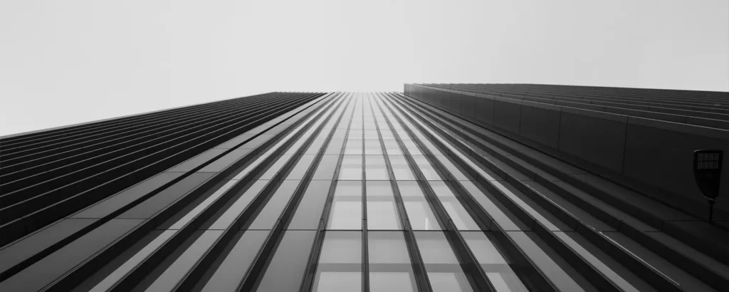 A black and white photo of a skyscraper from below.