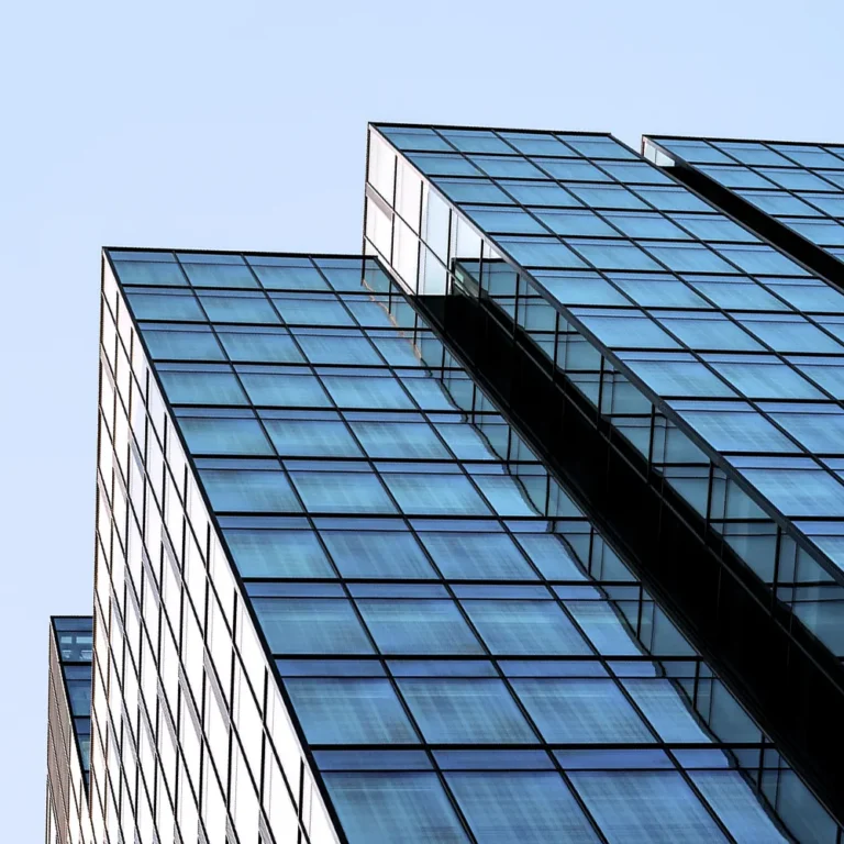 A glass skyscraper against a clear, blue sky.