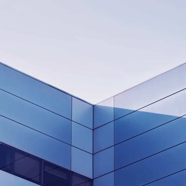 A glass skyscraper against a clear, blue sky.