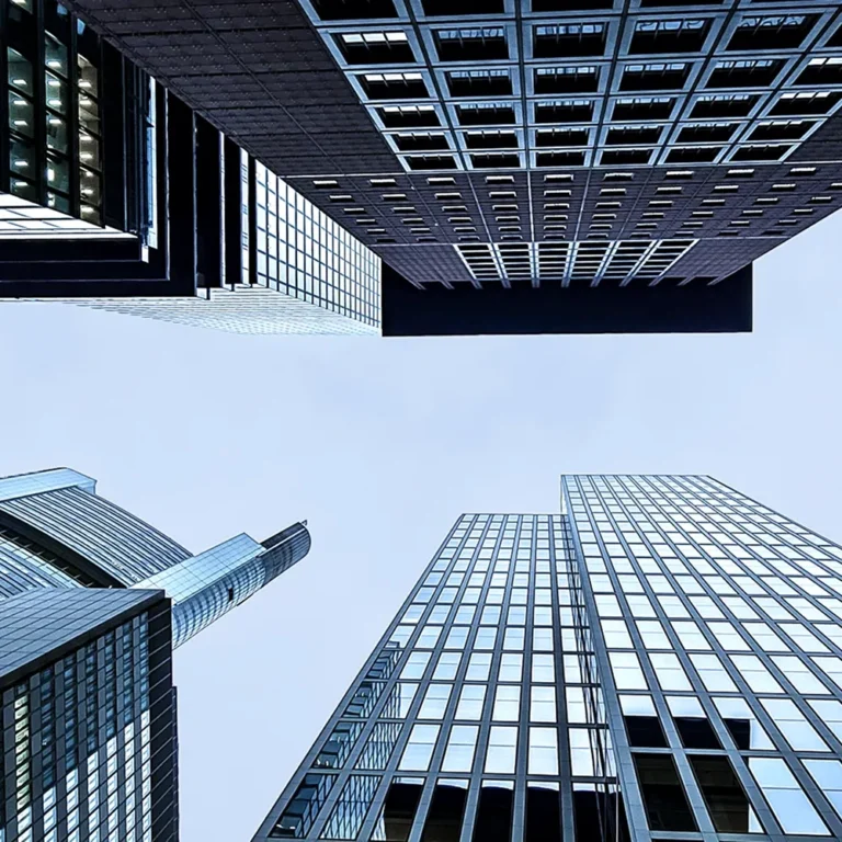 A glass skyscraper against a clear, blue sky.