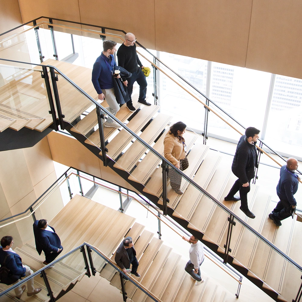 A group of people descending a staircase in an office building.
