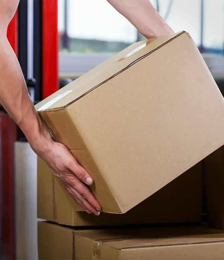 A person lifting a box from a stack of boxes.